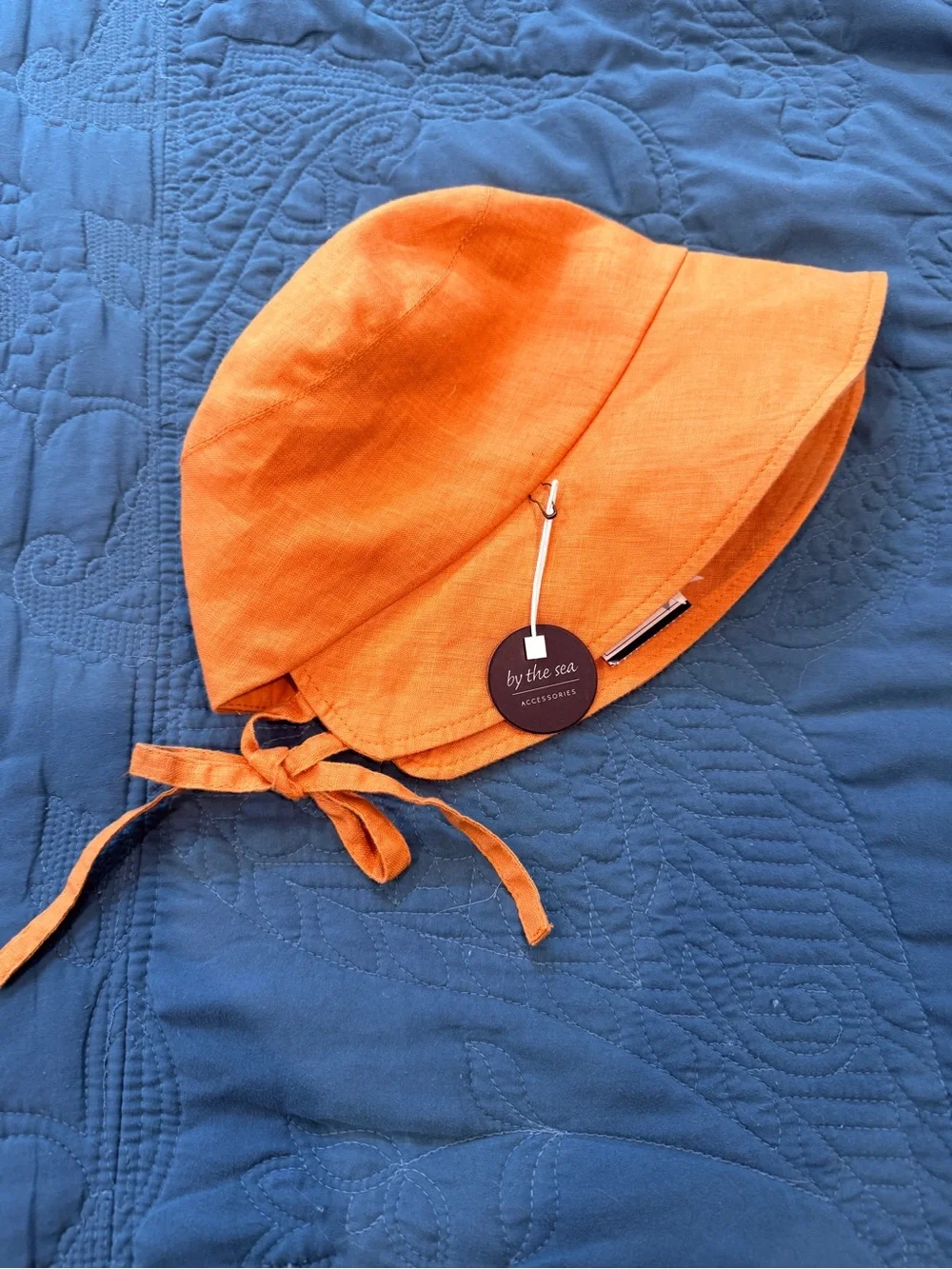 By The Sea Gold/Orange Kids Sun Bonnet/Hat with ties in back to adjust fit.